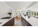 Open-concept kitchen with hardwood floors, wood cabinets, stainless steel appliances, and an island with seating at 2545 S Lowell Blvd, Denver, CO 80219
