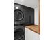 Modern laundry room with stainless steel appliances, wood countertop, and black cabinetry at 2545 S Lowell Blvd, Denver, CO 80219