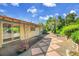 Scenic backyard featuring a covered patio, stone walkway, and mature trees at 11267 W Colorado Pl, Denver, CO 80232