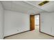 Bright unfinished basement with door leading to another room and white paneled walls at 11267 W Colorado Pl, Denver, CO 80232