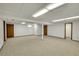 Spacious basement featuring neutral carpeting, ample lighting, and multiple doors at 11267 W Colorado Pl, Denver, CO 80232