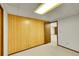 Basement showcasing wood-paneled walls, neutral carpet and access to another room at 11267 W Colorado Pl, Denver, CO 80232