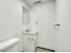 Compact basement bathroom with a simple vanity, toilet, and a mirrored wall cabinet at 11267 W Colorado Pl, Denver, CO 80232