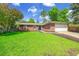 Charming single-story brick home with a well-manicured lawn and mature trees under a blue sky at 11267 W Colorado Pl, Denver, CO 80232