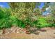 Delightful landscaping features stone walls, vibrant greenery, and a charming wooden staircase with flower pots at 11267 W Colorado Pl, Denver, CO 80232