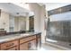 Bathroom boasts granite counters, wood cabinets, and large glass shower with tiled herringbone pattern and natural light at 3422 N Gold Bug Ct, Aurora, CO 80019