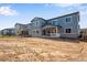 New construction home features a covered porch, stone accents, and a two-story design, set against a blue sky backdrop at 3422 N Gold Bug Ct, Aurora, CO 80019