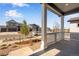 Cozy front porch with white columns and railings offers a welcoming view of the well-manicured neighborhood at 3422 N Gold Bug Ct, Aurora, CO 80019