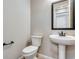 Modern powder room boasts pedestal sink, dark fixtures, and a comfort height toilet at 3422 N Gold Bug Ct, Aurora, CO 80019