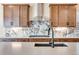 Close-up of the kitchen area: marble backsplash, a large sink in the island, and stainless appliances at 3422 N Gold Bug Ct, Aurora, CO 80019