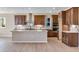 Modern kitchen with wooden cabinets, stainless steel hood, marble backsplash, and large center island at 3422 N Gold Bug Ct, Aurora, CO 80019