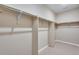 Spacious walk-in closet featuring neutral paint, carpet, and built-in shelving for optimal storage and organization at 3422 N Gold Bug Ct, Aurora, CO 80019