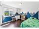 Well-lit bedroom features stylish mountain accent wall, hardwood floors, and ample natural light at 3715 E 139Th Pl, Thornton, CO 80602