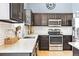 Modern kitchen features dark cabinets, stainless steel appliances, white subway tile backsplash, and stone countertops at 3715 E 139Th Pl, Thornton, CO 80602