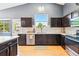Well-lit kitchen with stainless steel appliances, dark wood cabinets, and a window view at 3715 E 139Th Pl, Thornton, CO 80602