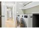 Well-lit laundry room features modern appliances, storage shelves, and neutral decor at 3715 E 139Th Pl, Thornton, CO 80602