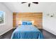 Cozy main bedroom featuring a stylish wood accent wall, plush bedding, and soft lighting at 3715 E 139Th Pl, Thornton, CO 80602
