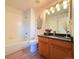 Well-lit bathroom with a shower-tub combo, and a modern vanity with a large mirror at 94 Vale St, Palmer Lake, CO 80133