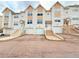 View of townhomes with a private garages and steps leading up to the front doors at 94 Vale St, Palmer Lake, CO 80133