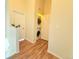 Hallway with stackable washer and dryer, wood-look flooring, and white doors at 94 Vale St, Palmer Lake, CO 80133