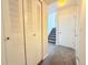 Hallway with neutral carpeting, white closet doors, and staircase to upper level at 94 Vale St, Palmer Lake, CO 80133