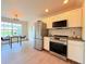 Well-lit kitchen with stainless steel appliances, white cabinetry, and adjacent dining area at 94 Vale St, Palmer Lake, CO 80133