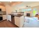 Open concept kitchen with stainless steel appliances, stone countertops, and seamless transition to living area at 94 Vale St, Palmer Lake, CO 80133
