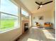 Living room with large windows showing green outdoor view and sleek black ceiling fan at 94 Vale St, Palmer Lake, CO 80133