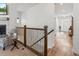Upstairs hallway featuring hardwood floors, a decorative railing, and a glimpse of the entryway at 11621 Colony Loop, Parker, CO 80138