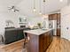 Modern kitchen featuring an island with pendant lighting, stainless steel appliances, and an open view to the living room at 11621 Colony Loop, Parker, CO 80138