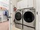 Modern laundry room with stainless steel washer and dryer and overhead storage at 11621 Colony Loop, Parker, CO 80138