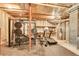 Unfinished basement with exposed ceiling, ductwork, and exercise equipment at 5688 Red Fern Ct, Littleton, CO 80125