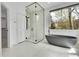 Modern bathroom with glass shower, soaking tub, and walk-in closet at 5688 Red Fern Ct, Littleton, CO 80125