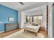 Bright bedroom features large windows, neutral rug, and blue accent wall at 5688 Red Fern Ct, Littleton, CO 80125