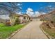 A luxurious home boasts a three-car garage and a well-manicured lawn complemented by elegant stone accents along the facade at 5688 Red Fern Ct, Littleton, CO 80125