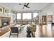 Bright living room featuring a stone fireplace, hardwood floors, and large windows with views of red rock formations at 5688 Red Fern Ct, Littleton, CO 80125