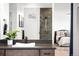 Modern bathroom features a sleek vanity with a vessel sink, walk-in shower, and a glimpse into the bedroom at 16262 W 95Th Ln, Arvada, CO 80007