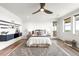 Cozy bedroom featuring a ceiling fan, modern decor, and natural light from the windows at 16262 W 95Th Ln, Arvada, CO 80007