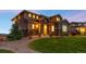 Charming two-story home with a beautifully landscaped front yard, stone accents, and warm exterior lighting at 16262 W 95Th Ln, Arvada, CO 80007