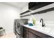Convenient laundry room with modern washer and dryer, built-in shelving, and a utility sink at 16262 W 95Th Ln, Arvada, CO 80007