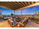 Covered deck featuring cozy seating, scenic views, and a relaxing swing at 16262 W 95Th Ln, Arvada, CO 80007
