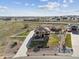 Aerial shot of the property with its long driveway, white fence, and proximity to open land at 16101 Iola St, Brighton, CO 80602