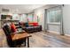 Cozy basement living room with comfortable seating, wooden floors, wet bar, and a window at 16101 Iola St, Brighton, CO 80602