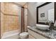 A well-lit bathroom with a sink, granite countertops, large mirror, toilet, and tiled shower/tub combo at 16101 Iola St, Brighton, CO 80602