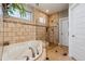 Relaxing bathroom showcasing a soaking tub, tiled shower, and neutral tile flooring at 16101 Iola St, Brighton, CO 80602