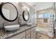 Bathroom featuring double sinks, granite countertops, modern fixtures, mirrors, and a tiled shower/tub combo at 16101 Iola St, Brighton, CO 80602