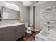 Bathroom features marble countertops, a soaking tub with a marble accent wall, and gray wall paint at 16101 Iola St, Brighton, CO 80602