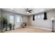 A brightly lit bedroom with large windows, a ceiling fan, and a door to the balcony at 16101 Iola St, Brighton, CO 80602