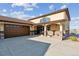 Exterior elevation features a two-car garage, covered porch, and beige stucco at 16101 Iola St, Brighton, CO 80602