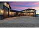 Exterior dusk view of a home featuring multiple garages and covered patio at 16101 Iola St, Brighton, CO 80602